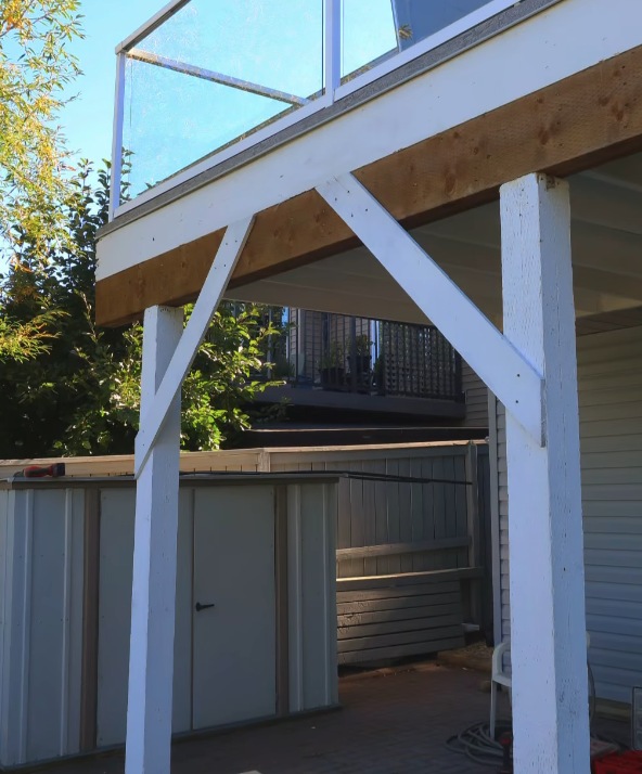 NuHammerConstruction elevated deck with glass railing and timber structural supports